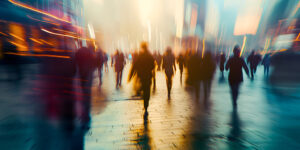 Blurred photo of people walking in a city square at sunset