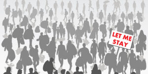 Crowd of displaced people isolated on background with one holding sign with red lettering saying "Let Me Stay"